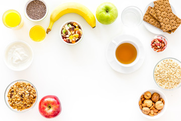 Ingredients for healthy breakfast. Fruits, oatmeal, yogurt, nuts, crispbreads, chia on white background top view copy space