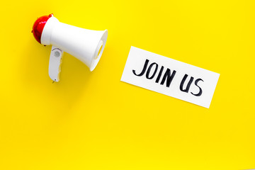 Membership concept. Hand lettering Join us near megaphone on yellow background top view copy space