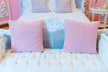 Beautiful pink fabric pillows with white wooden bed vintage classic interior decoration