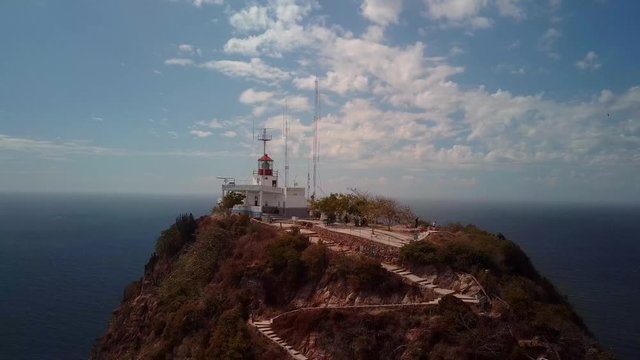 AERIAL: Lighthouse on a huge cliff with a hiking path