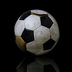 Old Soccer ball on black background