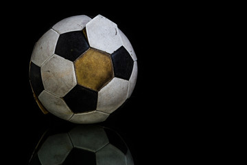 Fototapeta na wymiar Old Soccer ball on black background