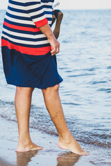 Woman walks along sandy beach