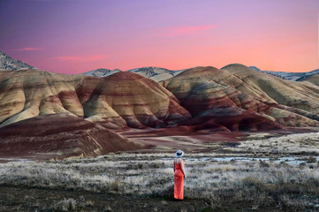 Vacation travel in Oregon. Woman enjoying the view of beautiful Painted Hills at sunset. John Day...