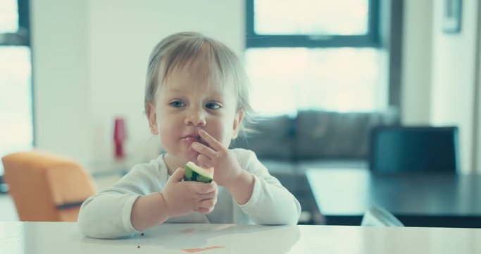 Little toddler boy eating watermelon at home