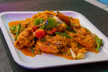 Shrimp in curry sauce in white plate on the table.