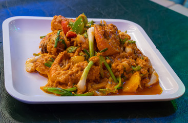 Shrimp in curry sauce in white plate on the table.