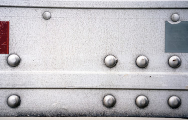 Background of aluminum semi trailer wall with rivets and stickers