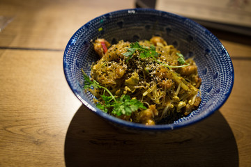 Chinese noodles in a blue plate on a wooden table