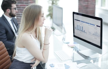 young business woman sitting at the desk together with a colleague.