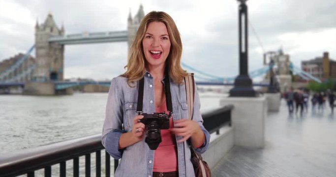Travel photographer taking pictures of the Tower Bridge, Portrait of woman tourist with her camera in London smiling, 4k