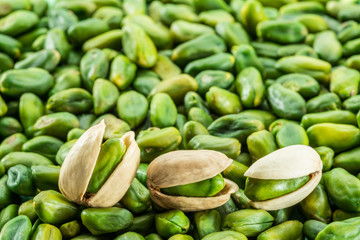 Lot of green pistachio nuts. Food background.
