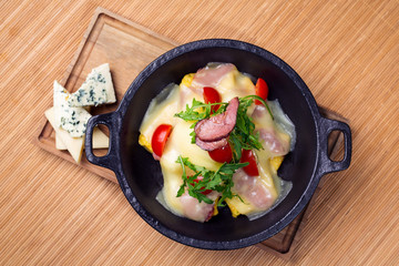 Meat stew served with melted cheese on wooden table