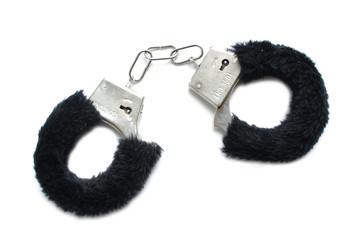 Handcuffs with fur on white background. Accessory for love games. black.   - obrazy, fototapety, plakaty