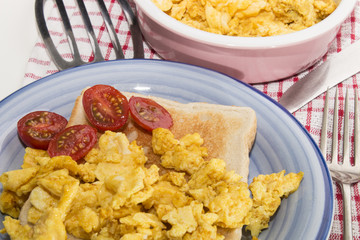 scrambled eggs on toast and sliced plum tomatoes