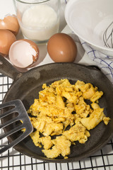 organic scrambled eggs in a cast iron pan and  whisk in a bowl