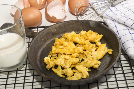 organic scrambled eggs in a cast iron pan and  whisk