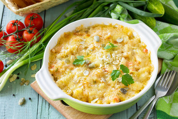 Casserole crumble with red fish, white bread and cheese on the kitchen wooden table. Proper nutrition.