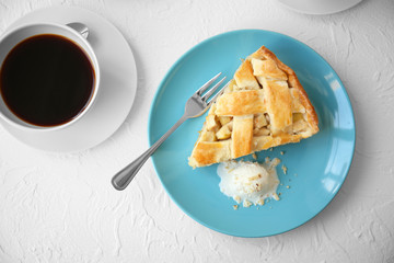 Plate with piece of tasty apple pie and cup of coffee on table