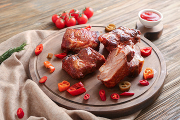 Delicious grilled ribs with sliced chili pepper on wooden board