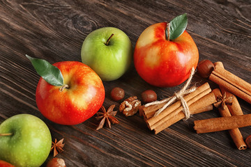 Fresh apples and cinnamon sticks on wooden background