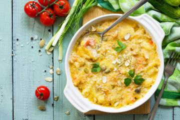 Casserole crumble with red fish, white bread and cheese on the kitchen wooden table. Proper nutrition. Top view flat lay background, copy space.