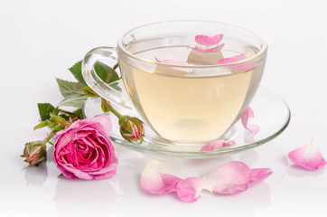 Fototapeta na wymiar Glass cup of Tea with roses and petals