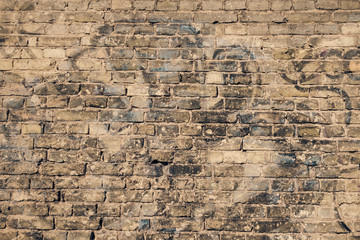 Old brick wall with graffiti fragments
