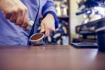 Photo of barista with mortar with coffee in hands