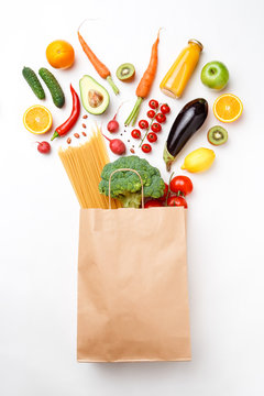 Photo of paper bag with vegetables, fruits and spaghetti