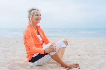 Happy supple mature blond woman on a beach
