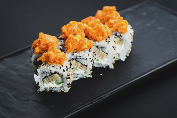 Set of different sushi rolls on black background