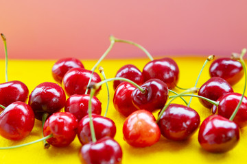 closeup of red cherries on a yellow table