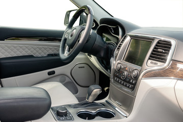 Car dashboard and steering wheel. The interior of a modern luxury SUV type car.Kokpit trimmed with...