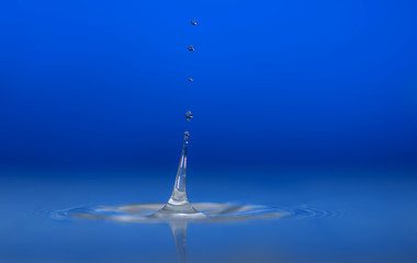 Water drop falling into water making a perfect droplet splash