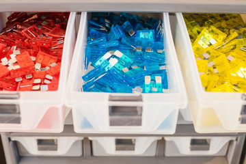 colorful electrical automotive car fuse red, blue,yellow colors in desk drawer for sale in electric shop.