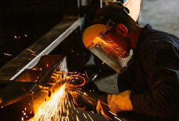 Man work with welding.Repairs the metal structure in the car.