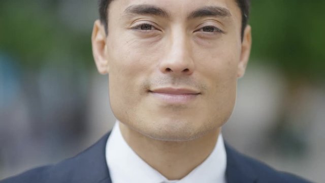 Portrait of handsome Japanese man in a suit smiling to camera