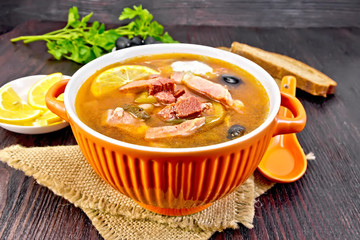 Solyanka with olives in bowl on board