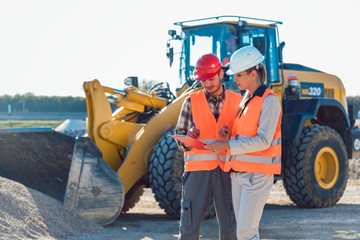 Man and woman worker on construction site talking