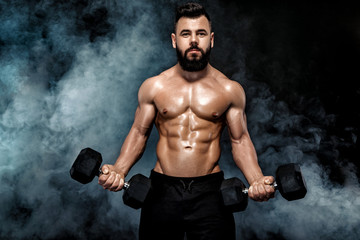 Fototapeta na wymiar athletic muscular man doing exercises with dumbbells.