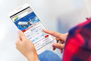 Young woman buying air tickets online on tablet computer