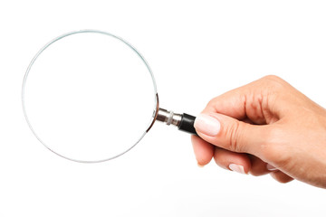 Female hand with a magnifying glass on a white background