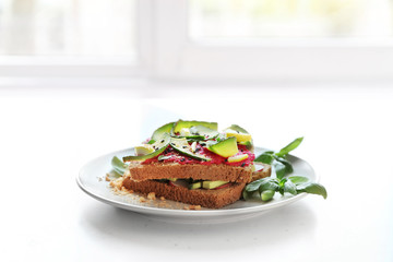 Delicious toasts with avocado on plate