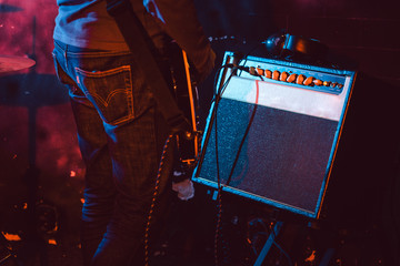Guitar player in front of amplifier playing music