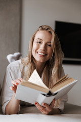 Smiling young woman holding blank cover open book