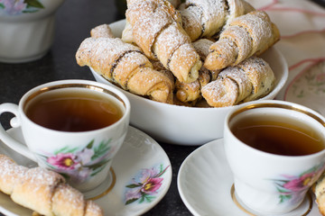 Croissants (bagels) with poppy seeds and tea. Morning tea with croissants.