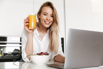 Satisfied young woman drinking orange juice
