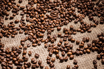 high angle view of roasted coffee beans spilled on sackcloth