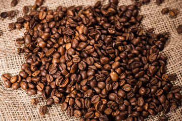 close-up shot of heap of roasted coffee beans on sackcloth